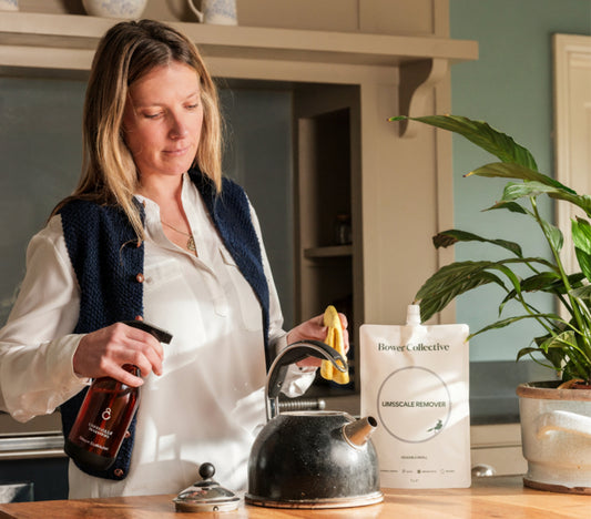 Woman cleaning kitchen surface and kettle with Bower Products. 